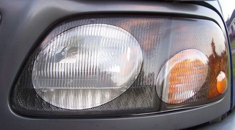 1998 Ford F-150 - Close-up of a vehicle's headlight assembly a mesh overlay and an amber turn signal light.