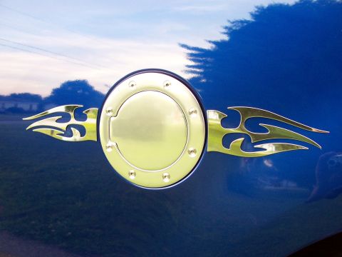 1998 Ford F-150 - A chrome fuel door with flame decals is visible on the side of a blue vehicle.