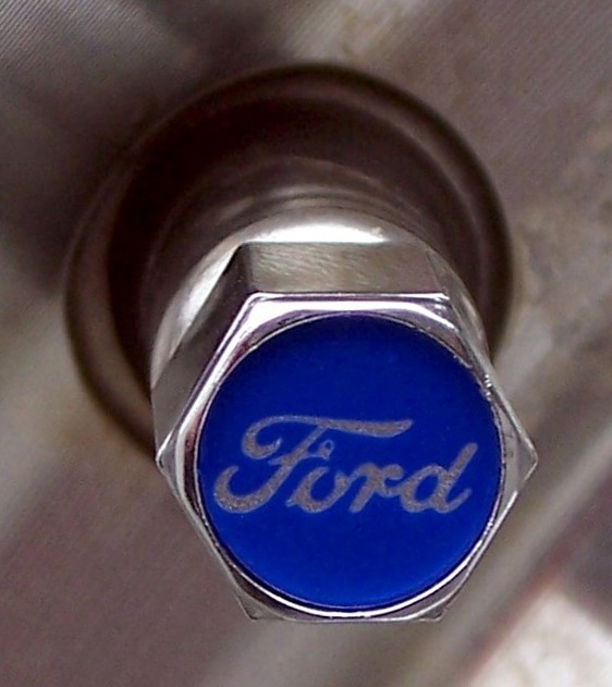 Close-up of a blue lug nut with a silver Ford logo