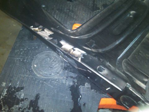 1993 Ford Bronco - Close-up of a damaged black plastic trim piece, showing exposed metal and screw threads.