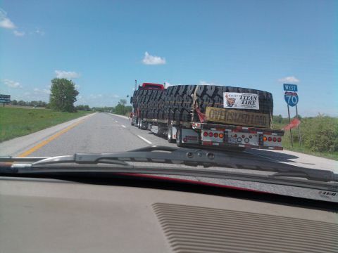 1989 Ford Bronco - A truck transports a load of massive tires on a highway, with a 'West 70' sign visible.