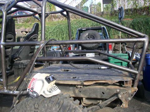 1979 Ford Bronco - Custom buggy frame with roll cage, spare tire, and welding mask. A 1979 Ford Bronco is visible in the background.