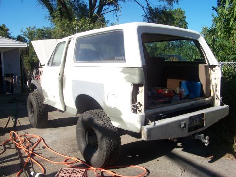 1989 Ford Bronco - White SUV undergoing bodywork, showing exposed interior and removed rear bumper.