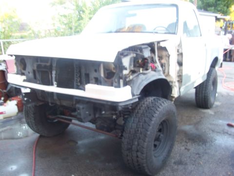 1989 Ford Bronco - Front view of a 1989 Ford Bronco undergoing body work, with the grille and front fenders removed.