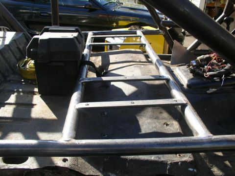 1979 Ford Bronco - The interior of a custom off-road vehicle shows a roll cage, battery box, and wiring, suggesting significant modification.