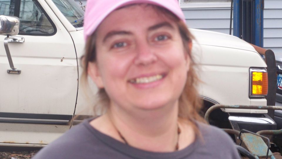 Woman in pink hat in front of a white 1987 Ford F-Series truck