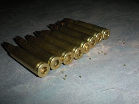 1996 Ford Bronco - A collection of brass cartridges are laid out on a textured gray surface, with a website logo visible.