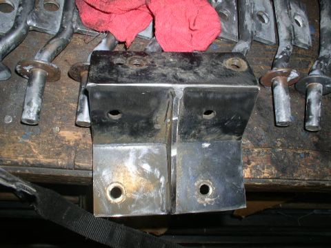 1979 Ford Bronco - Close-up of metal brackets and a red cloth on a workbench, with visible text at the bottom right.