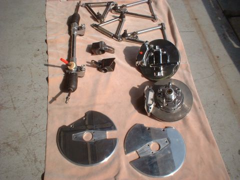 1971 Ford Ranchero - A collection of polished chrome automotive suspension and braking components are displayed on a fabric surface.