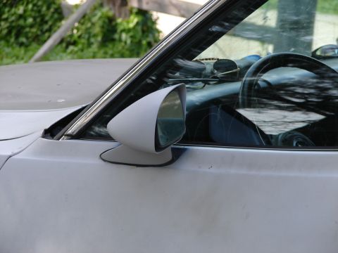 1973 Ford Ranchero - Side view of a white car's door and mirror, revealing part of the interior with a steering wheel.