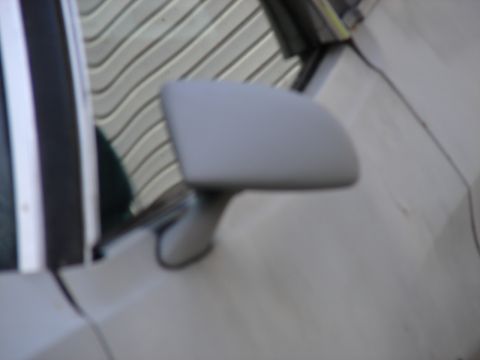 1973 Ford Ranchero - Side mirror of a car, with a reflection of a ribbed garage door in the glass.