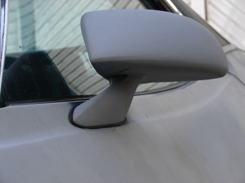 1973 Ford Ranchero - A close-up view of a car's side mirror, showing its mounting and the surrounding body panel.