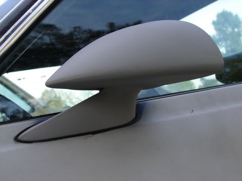 1973 Ford Ranchero - A close-up view of a vehicle's side mirror, showing its mounting and surrounding body panel.