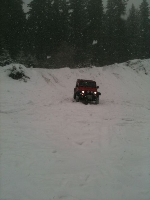 2005 Jeep Wrangler - 2005 Jeep Wrangler navigating a snowy mountain road during a snowfall.