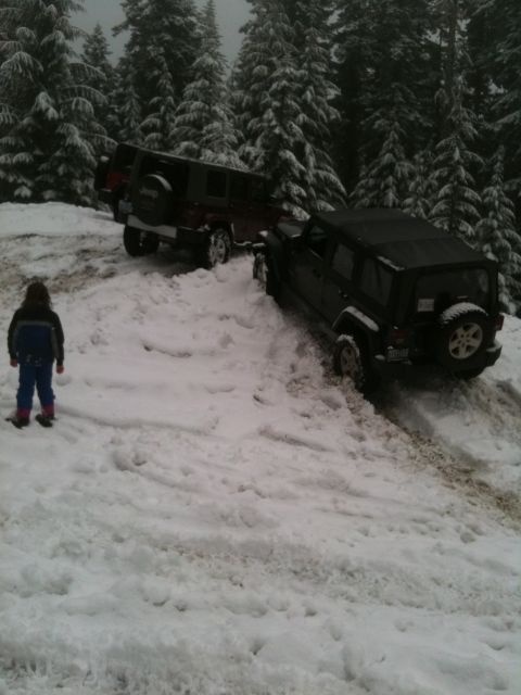 2005 Jeep Wrangler - Two Jeep Wranglers navigate a snowy, wooded trail, with one vehicle appearing to be stuck.