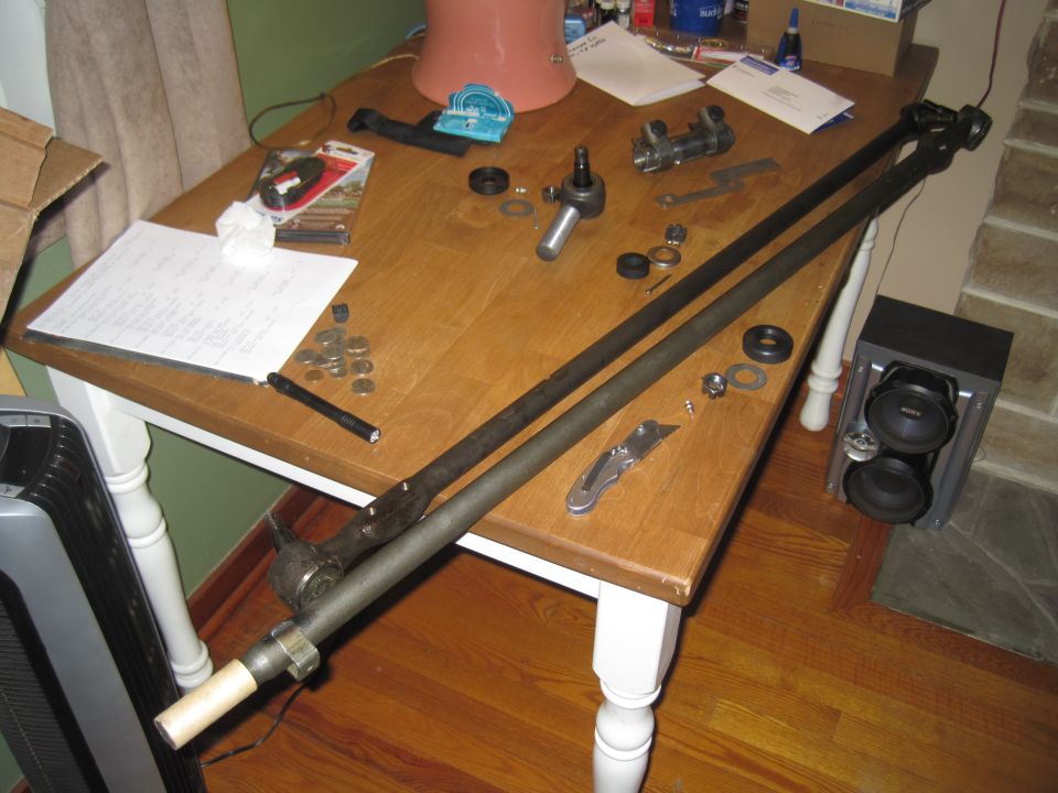 Steering linkage parts laid out on a wooden table