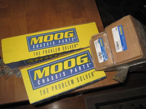 1979 Ford Bronco - Boxes of MOOG chassis parts are stacked on a wooden surface.