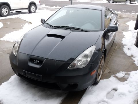 2006 Ford E350 - Front view of a black Toyota Celica GT-S with a hood scoop, parked in the snow.
