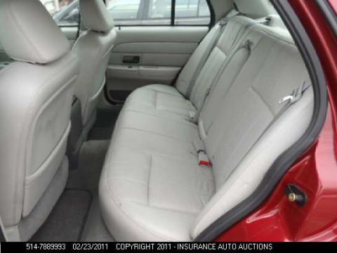 2007 Ford Crown Victoria - The interior of a car shows light-colored upholstery on the rear seats and door panels.