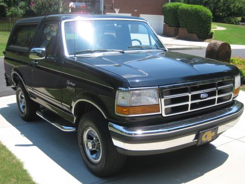 1992 Ford Bronco - This black 1992 Ford Bronco features a distinctive grille and chrome trim, parked in a driveway.