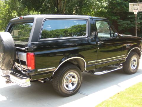 1992 Ford Bronco - This black 1992 Ford Bronco is shown from the rear three-quarter angle, parked outdoors.