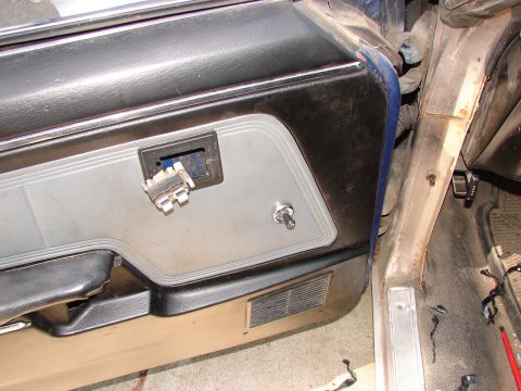 1973 Ford Ranchero - Close-up of a car's interior door panel showing exposed wiring and a toggle switch.