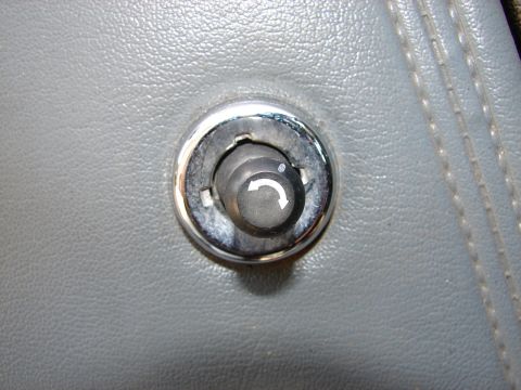 1973 Ford Ranchero - Close-up of the interior door lock knob, a curved arrow symbol, on a 1973 Ford Ranchero.