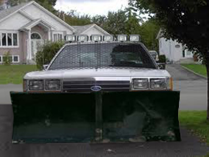 1994 Ford Bronco - Head-on view of a silver Ford sedan crudely photo-edited into an apocalypse rig, fitted with a wide green snow-plow blade across the front,…