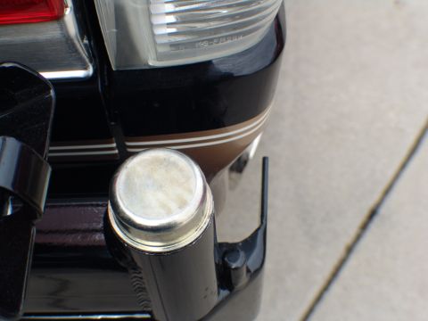 1996 Ford Bronco - Close-up of a vehicle's rear bumper, showing a chrome cap and decorative stripe.