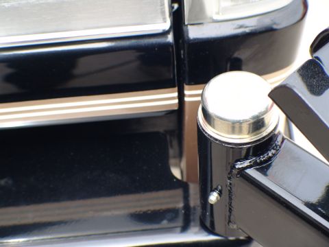 1996 Ford Bronco - Black metal bracket with silver cap and triple stripe trim, likely part of a rear bumper assembly.