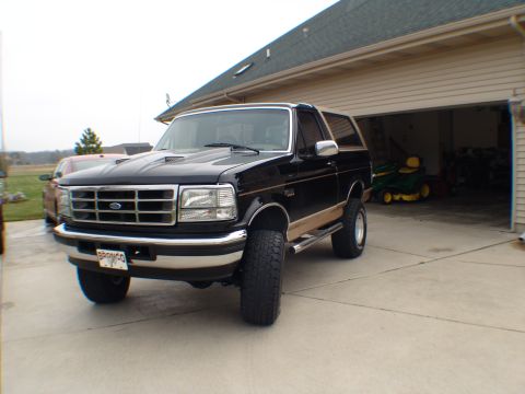1996 Ford Bronco - This black 1996 Ford Bronco features tan trim and appears to be lifted, parked in a driveway.