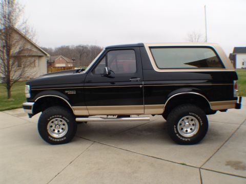1996 Ford Bronco - Side view of a black and tan Ford Bronco, likely from the mid-1990s.