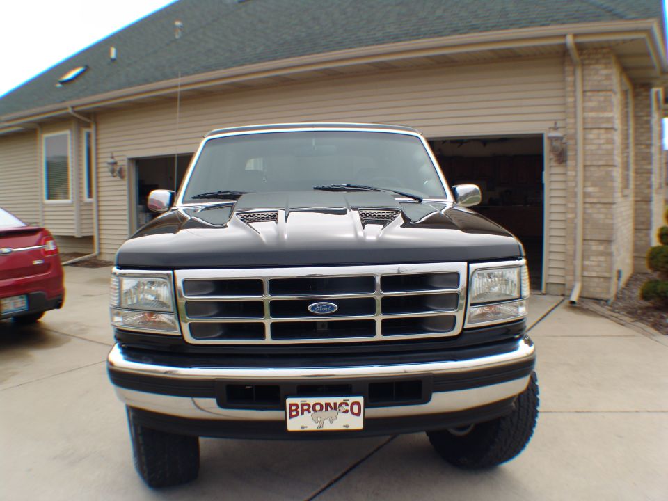 Front view of a black Ford Bronco with a chrome grille and a license plate that says BRONCO