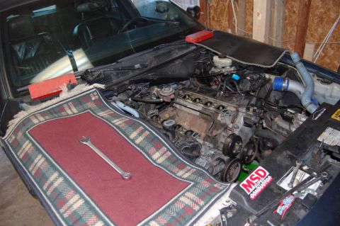 1985 Mercury Grand Marquis - The engine is exposed for maintenance, with tools laid out on a protective cover.