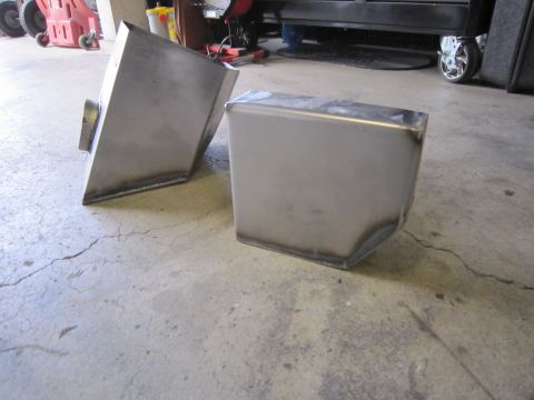 2008 Jeep Wrangler - Two custom metal intake parts are shown on a concrete floor, with welding visible on their seams.