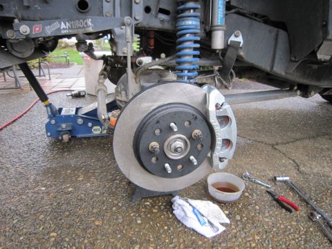 2008 Jeep Wrangler - Close-up of a silver brake caliper and rotor on a Jeep Wrangler, with visible blue coilover suspension and "ANTIROCK" branding on the sway…