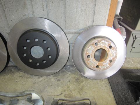 2008 Jeep Wrangler - Comparison of a new brake rotor with a black hat next to a used, rusty brake rotor.