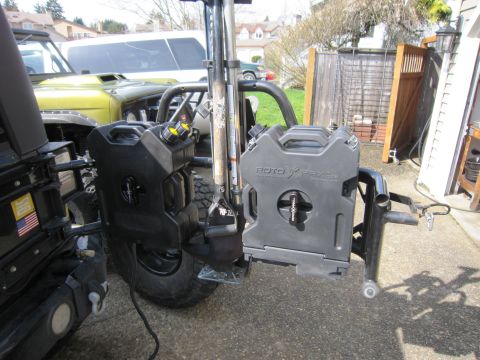 2008 Jeep Wrangler - Two Rotopax fuel cans are mounted on the rear of a Jeep, with another Jeep visible behind it.