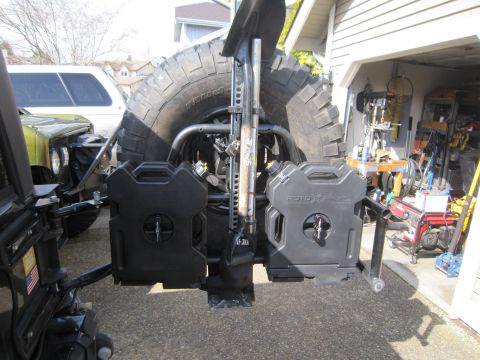 2008 Jeep Wrangler - Rear view of a spare tire carrier with auxiliary fuel cans and a shovel mount.
