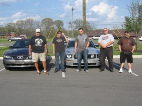 2007 Ford Mustang - Five men pose with two Ford Mustangs in a parking lot on a sunny day.