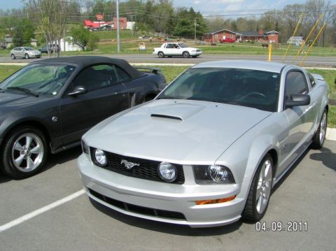 2007 Ford Mustang - Silver S197 Ford Mustang GT coupe parked in a lot, shown from the front three-quarter with hood scoop, running-pony grille badge, round dri…