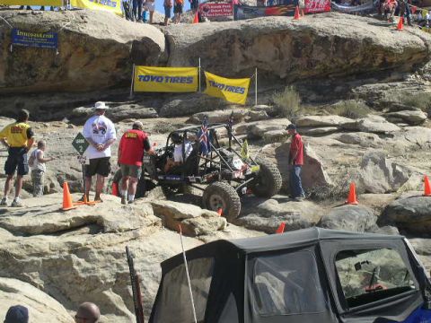 1979 Ford Bronco - An off-road buggy navigates a rocky course with spectators observing the event.