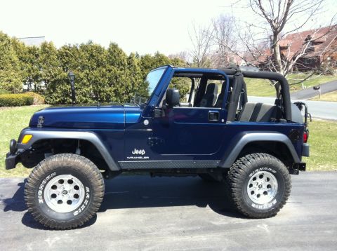 1972 Ford Ranchero - A dark blue Jeep Wrangler shown in profile with its soft top and doors removed, featuring a lift kit and chrome wheels with Maxxis mud tire…