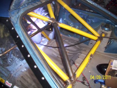 1995 Ford Probe - Roll cage installation in progress, with welding sparks visible inside the car's interior.