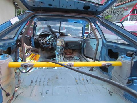 1995 Ford Probe - Interior view of a heavily modified blue car, stripped down and fitted with a roll cage and safety bar.