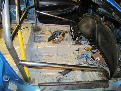 1995 Ford Probe - Interior of a race car, stripped down and fitted with a roll cage, with tools present.