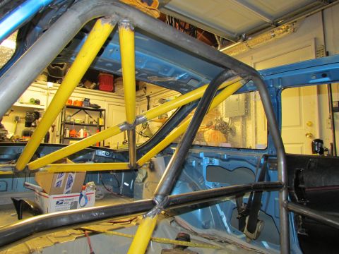1995 Ford Probe - Custom roll cage installation in progress inside a vehicle's interior.