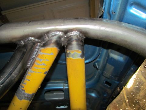 1995 Ford Probe - Welding work on a roll cage inside a vehicle's interior.