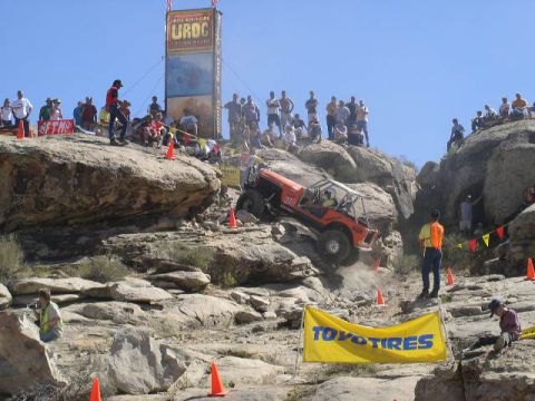 1979 Ford Bronco - Spectators watch an off-road vehicle tackle a steep, rocky incline during a competition.