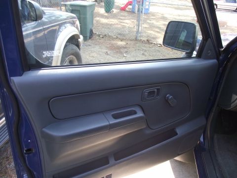 2004 Nissan Xterra - View of the interior door panel and a dark SUV parked outside the blue vehicle.